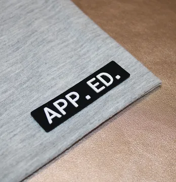 Нашивка "App. ed." з об'ємним лого 60*15 мм чорного кольору з білим написом