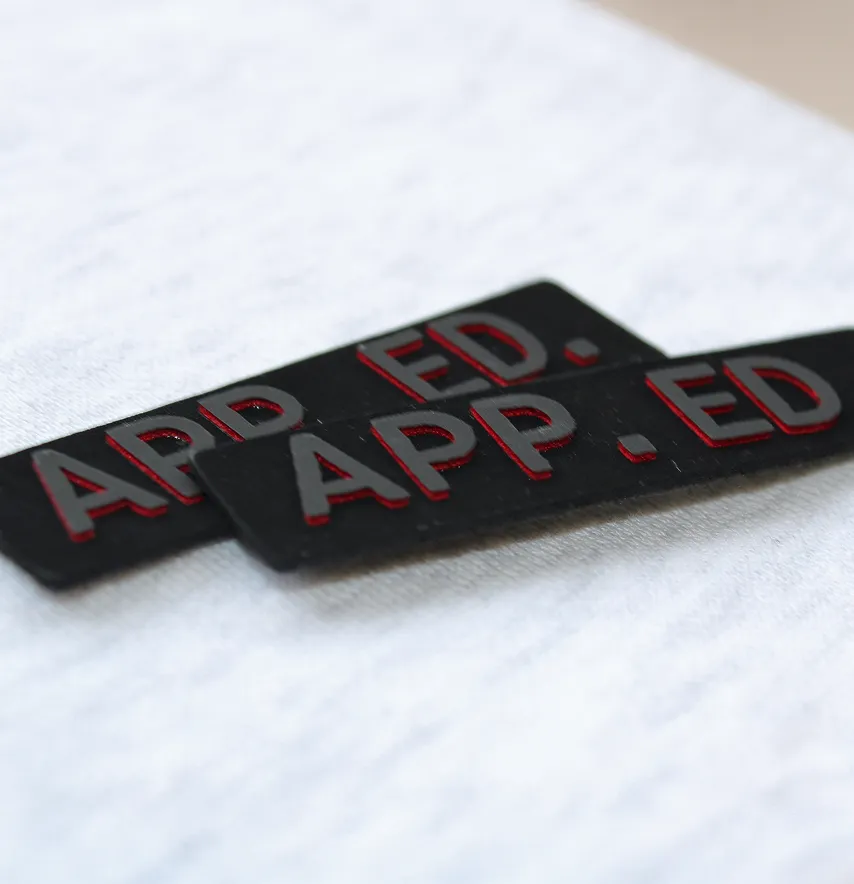Нашивка "APP.AD" 60*20 мм чорного кольору з чорно-червоним прорезиненим лого-1